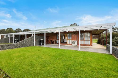 a house with a large lawn in front of it at Summerfield Winery and Accommodation in Moonambel