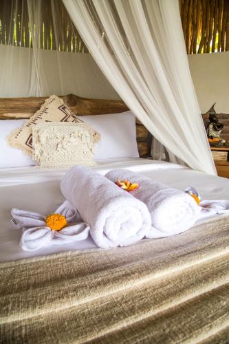 a bed with towels and flowers on it at ECOZY by Biji Valley in Selat