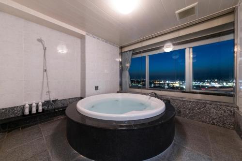 a bath tub in a bathroom with a window at ホテル ブルジュア 久留米 Hotel Bvljua -レジャーホテル- in Kurume