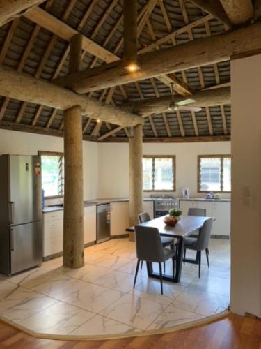 Una cocina y un comedor con mesa y sillas. en Fale Tonga Guesthouse, en Puke