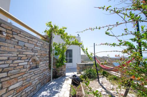 a view of the garden from the side of a brick building at Ios stylish house Panoramic Sea and Sunset view in Ios Chora