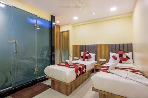 a bedroom with two beds and a shower at Hotel BKC Corporate Inn in Mumbai