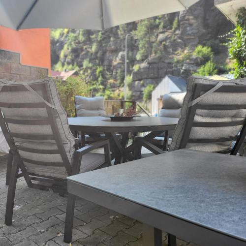 two chairs and a table with an umbrella on a patio at Apartment Villa Hřensko 132 in Hřensko