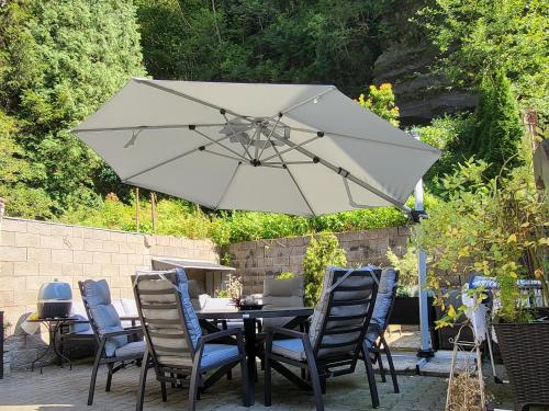 a table with chairs and an umbrella on a patio at Apartment Villa Hřensko 132 in Hřensko