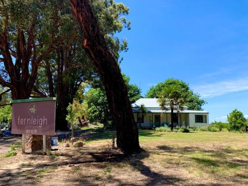 a sign in front of a tree and a house at Fernleigh Accommodation in Goughs Bay
