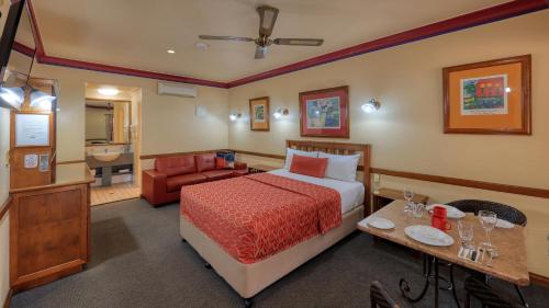 Habitación de hotel con cama y baño en Dalby Homestead Motel, en Dalby