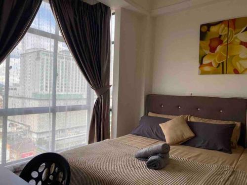 a bedroom with a bed with a large window at 2 Bedroom Apartment Next To Historical Spots in Melaka