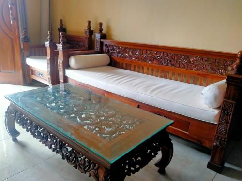 a couch with a table and a bench with a coffee table at Suta Lovina House in Lovina