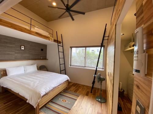 a bedroom with a loft bed and a window at FUSHIME in Motobu