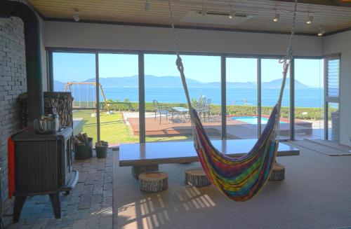 a room with a hammock and a view of the ocean at Seaside Villa SASAO in Aji