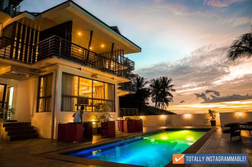 a house with a swimming pool in front of it at AV Suites in Puerto Galera