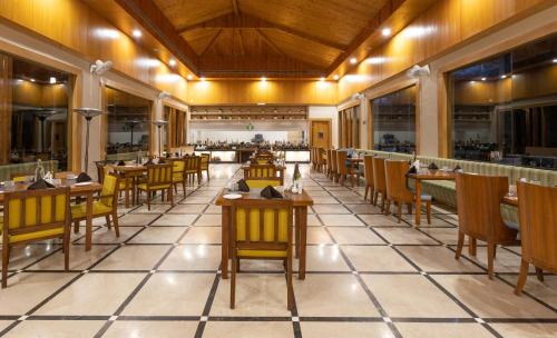 een restaurant met tafels en stoelen in een kamer bij Punarnava Resort & Spa in Dehradun