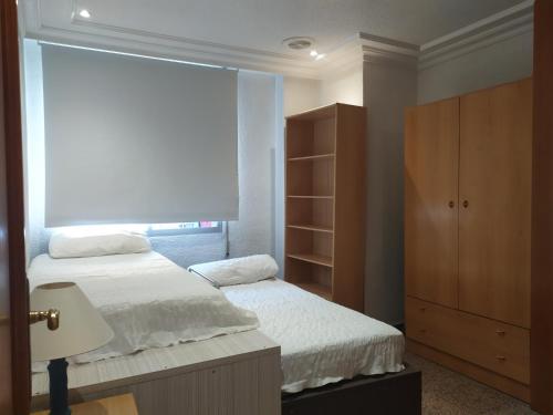 a bedroom with two beds and a window at Major del Pla 25 in Elche