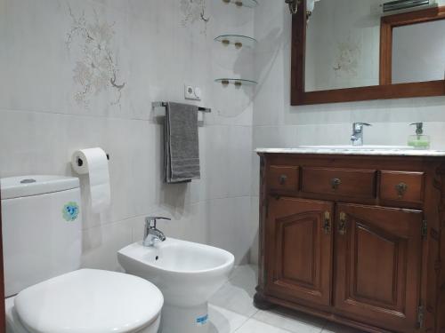 ein weißes Bad mit einem WC und einem Waschbecken in der Unterkunft Major del Pla 25 in Elche