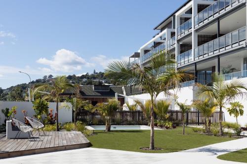 a building with palm trees in front of it at Oceanview Retreat in Nelson
