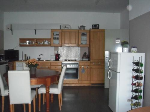 eine Küche mit einem Tisch und einem weißen Kühlschrank in der Unterkunft Pension Ackermann in Mayen
