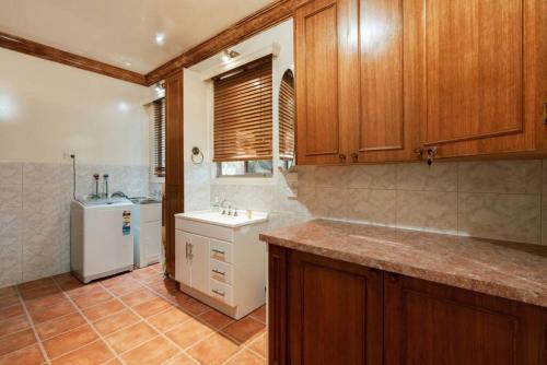 a kitchen with wooden cabinets and a sink and a refrigerator at Olinda Nature Sunset Apartment in Olinda