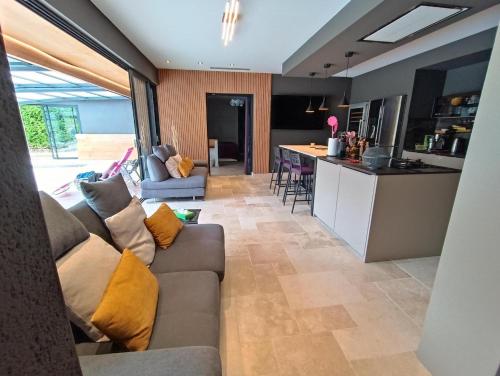 - un salon et une cuisine avec un canapé et un comptoir dans l'établissement Villa reposante près de Vayrac avec piscine privée, à Vayrac