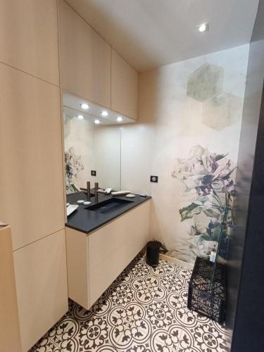 La salle de bains est pourvue d'un lavabo et d'une peinture murale. dans l'établissement Villa reposante près de Vayrac avec piscine privée, à Vayrac