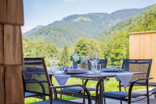 a table with chairs and wine glasses on a patio at DAS Hintersee in Hintersee
