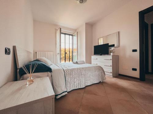 1 dormitorio con 1 cama, vestidor y TV en Appartamento Incantevole a 100metri dal mare e vicino a pista ciclabile en Imperia