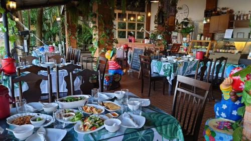 a table with plates of food on it in a restaurant at On The Hill Karon Resort in Karon Beach