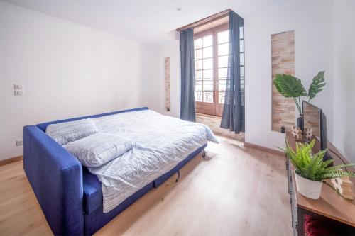 a bedroom with a blue bed and a window at Appartement Contemporain au coeur du centre ville in Mâcon