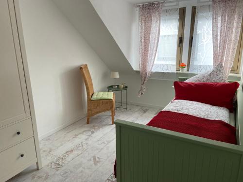 a bedroom with a bed and a chair and a window at Haus Elsternest in Klotten