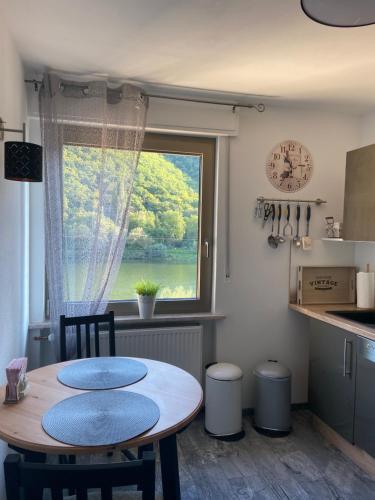 a kitchen with a table with two chairs and a window at Haus Elsternest in Klotten