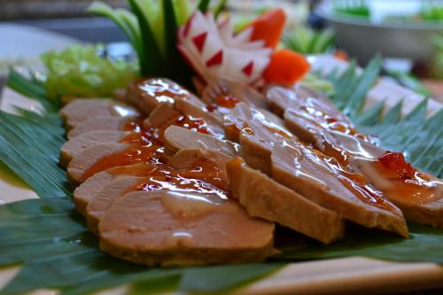 a plate of food with meat and sauce on a leaf at Sheraton Khalidiya Hotel in Abu Dhabi