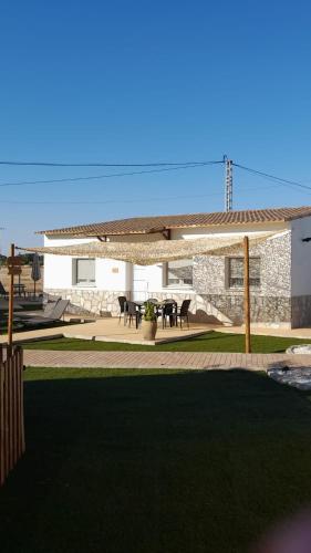 a patio with a pavilion with a table and chairs at ALAMANCHA in Casas de los Pinos