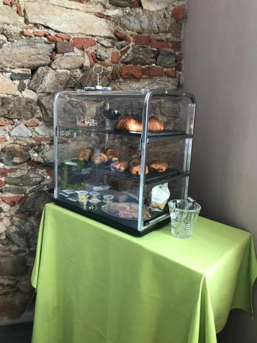 a table with a green table cloth and a display of pastries at B&B Villa Antilia in Busca
