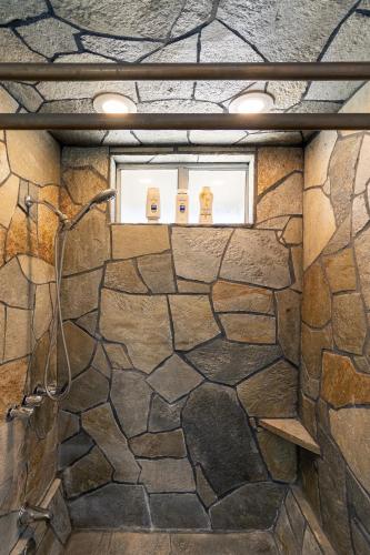 a bathroom with a stone wall and a window at Desert Ruby in Yucca Valley