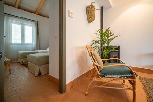 a room with a rocking chair and a bedroom at Apartamento para pareja, Finca Contrabando. Sanlucar del Guadiana in Sanlúcar de Guadiana
