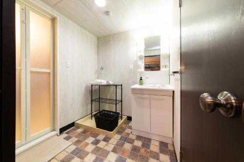 Un baño con lavabo, inodoro y espejo. en Stay Hakata, en Fukuoka