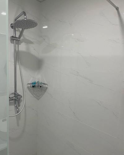 a bathroom with a shower with white marble walls at Tsaghkadzor Alvina complex in Tsaghkadzor