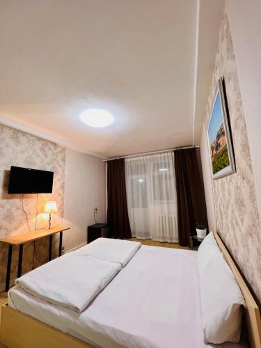 a bedroom with a large white bed and a desk at Khongor Guest house & Tours in Ulaanbaatar