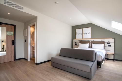 sypialnia z łóżkiem i kanapą w obiekcie Hotel Bed4U Santander w mieście Santander