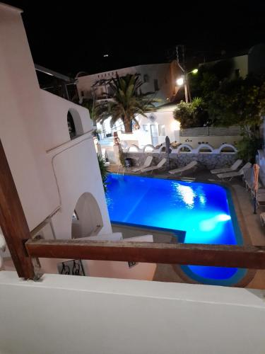 a swimming pool at night in a resort at Villa Markos in Perissa