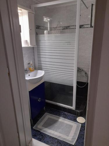 a small bathroom with a shower and a sink at Villa Markos in Perissa