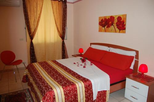 a bedroom with a bed with red pillows on it at Albicocche House in Giarre