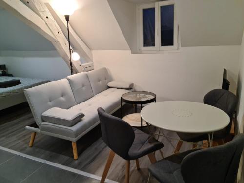 sala de estar con sofá y mesa en Beaugency-1 sur la route des Châteaux, en Beaugency