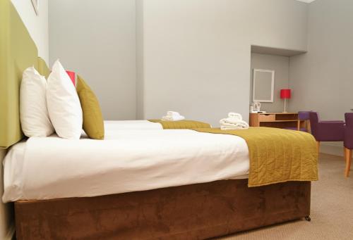 a bedroom with a large bed with white sheets and pillows at The Portpatrick Hotel by Compass Hospitality in Portpatrick