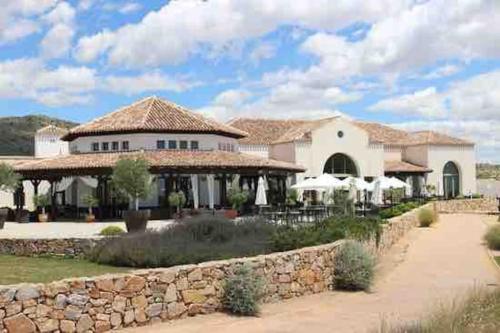 Casa blanca grande con pared de piedra en Villa para disfrutar en el Valle Golf Resort, en Murcia