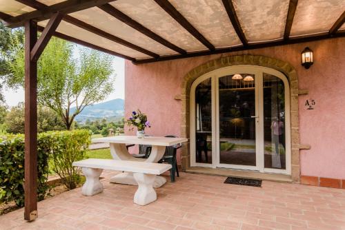 um pátio com uma mesa e um banco em Residence Borgo Felciaione em Riparbella