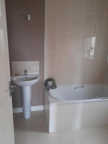 a bathroom with a sink and a bath tub and a sink at 112 Roseberry Hill in Newbridge