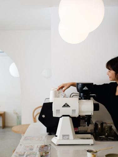 a woman standing behind a microscope on a table at Evergreen Cafe and Hotel in Chiang Mai