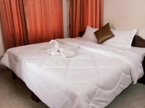 a white bed with two towels on top of it at Ocean Stay in Nedumbassery