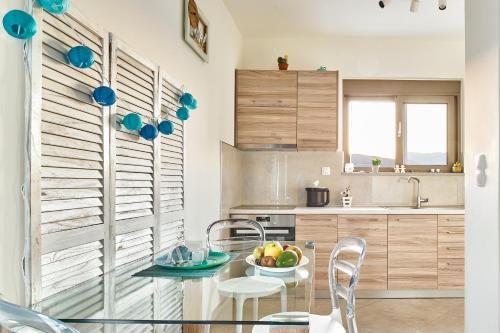 a kitchen with a glass table with a bowl of fruit on it at Lydia's Apartments in Kissamos