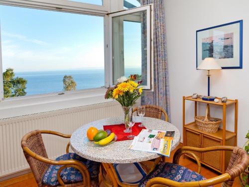 a table with a vase of flowers and fruit on it at Apartment Feodora in Sassnitz